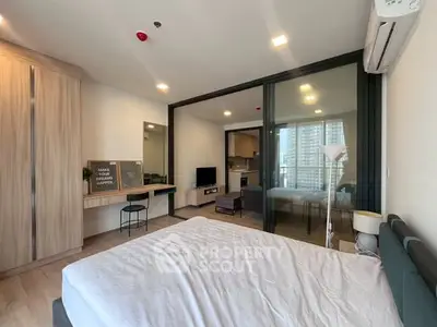 Modern bedroom with glass partition and view into cozy living area