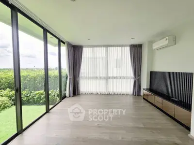 Spacious modern living room with large windows and garden view