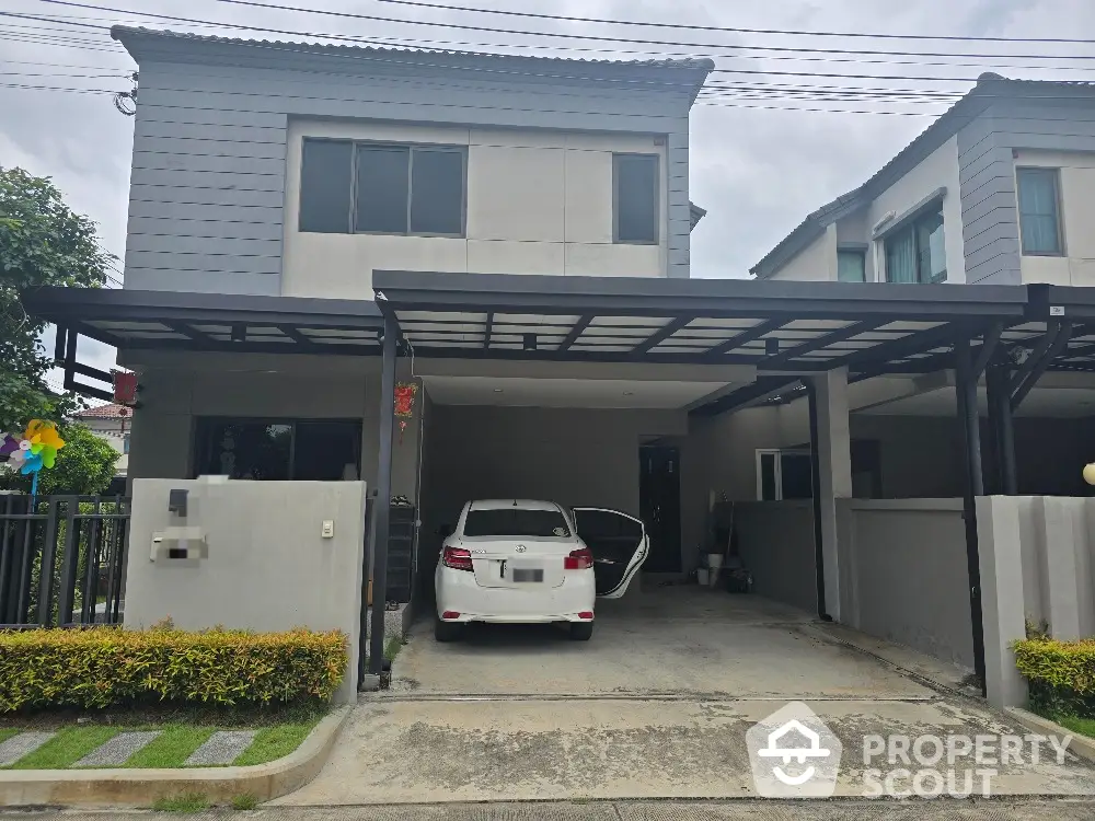 Modern two-story house with carport and well-maintained driveway in suburban neighborhood.