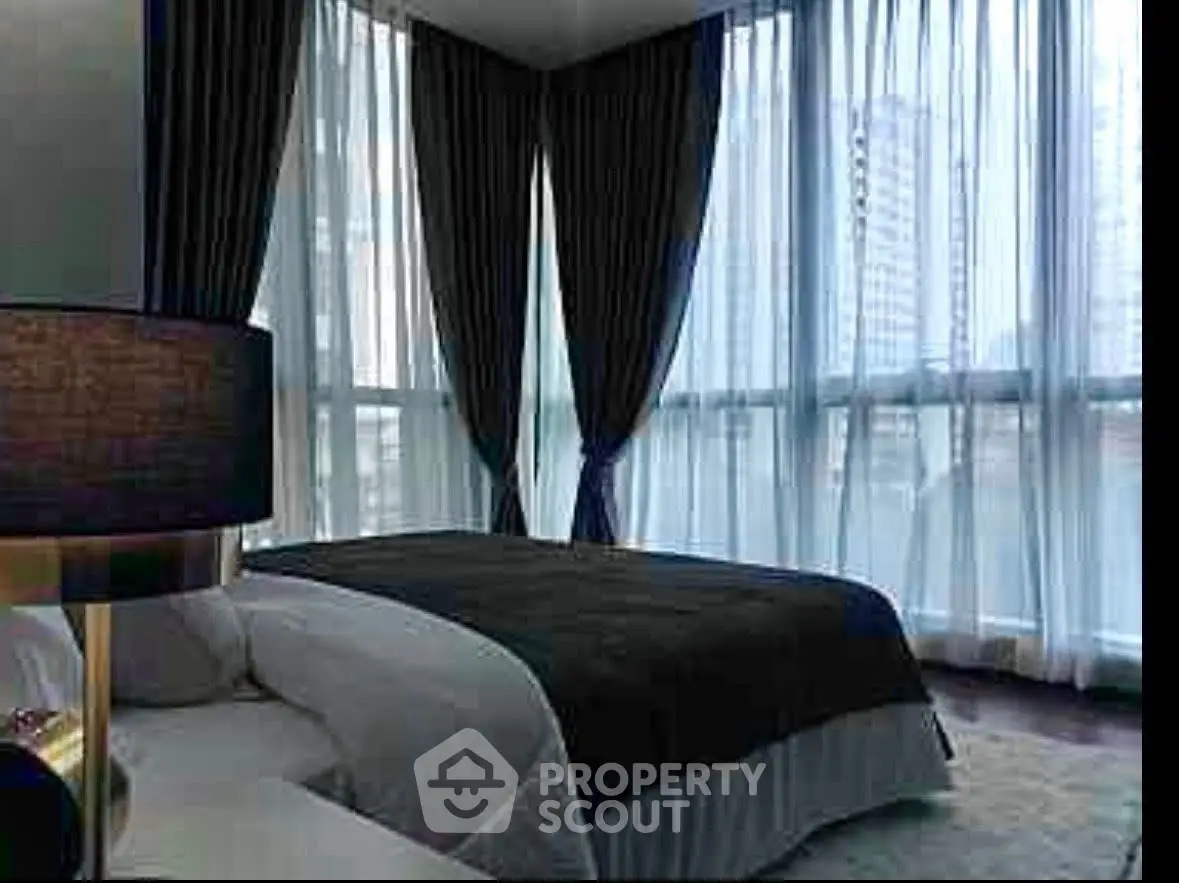 Luxurious bedroom with floor-to-ceiling windows and elegant curtains in a modern high-rise apartment.