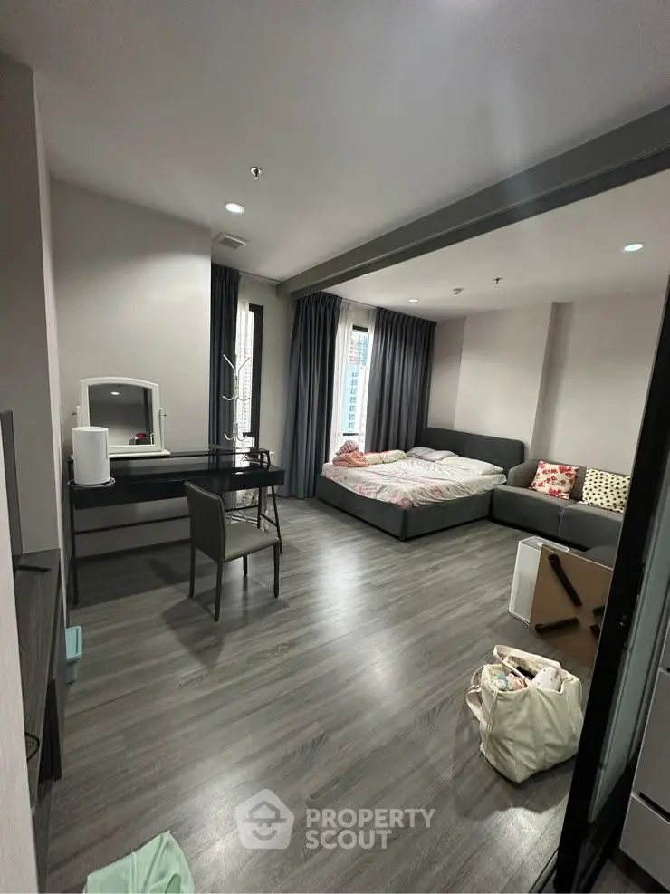 Modern bedroom with sleek flooring and cozy bed setup in a stylish apartment.