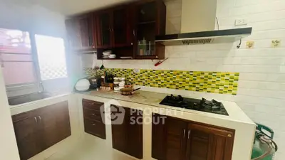 Charming kitchen with gas stove and vibrant backsplash in cozy home