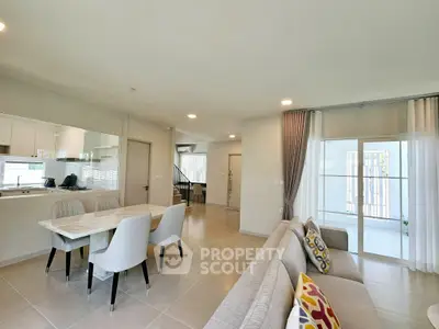 Spacious modern living room with open kitchen and elegant dining area, perfect for family gatherings.