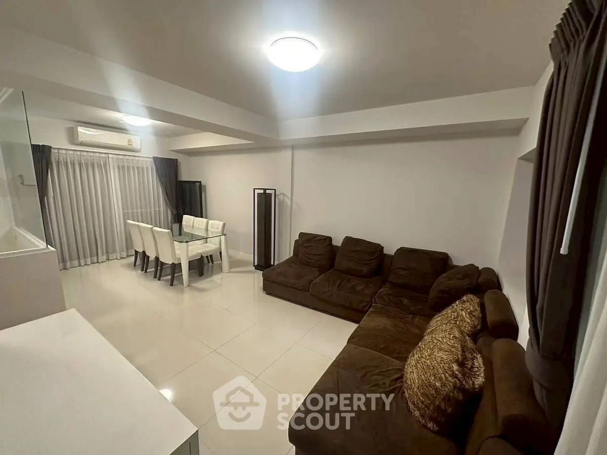 Spacious modern living room with elegant dining area and plush seating.