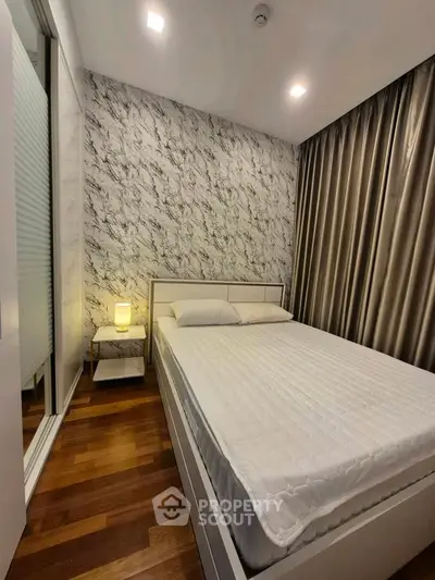 Modern bedroom with stylish marble accent wall and cozy lighting