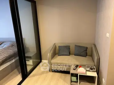 Cozy living room with modern sofa and sliding glass door to bedroom