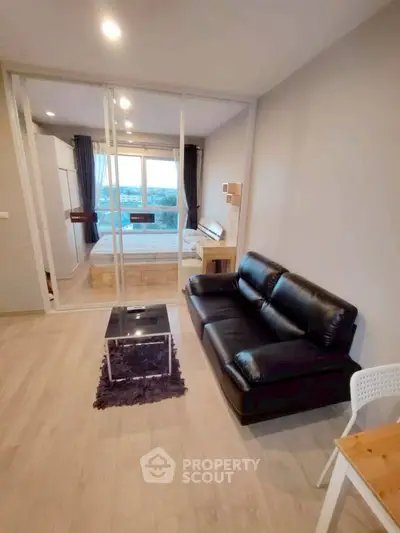 Modern studio apartment with glass partition, cozy living area, and scenic view.