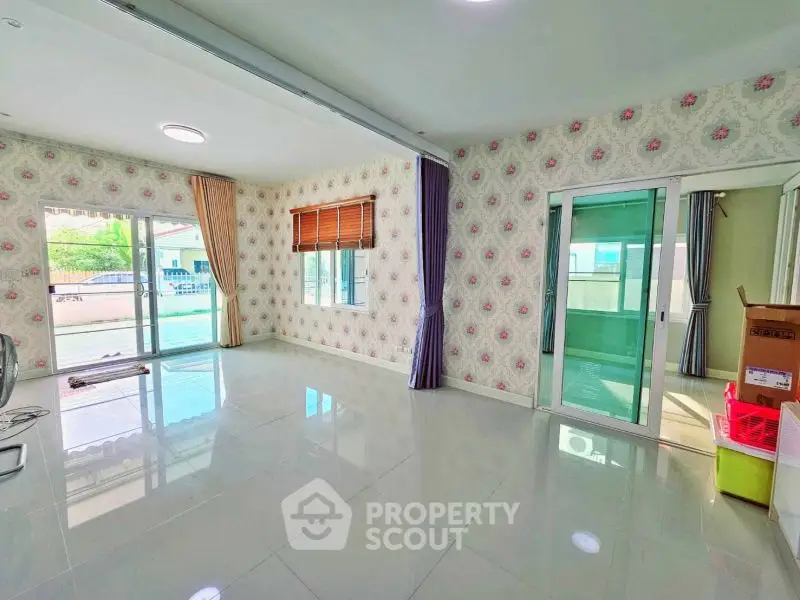 Spacious living room with sliding glass doors and elegant wallpaper, perfect for modern living.