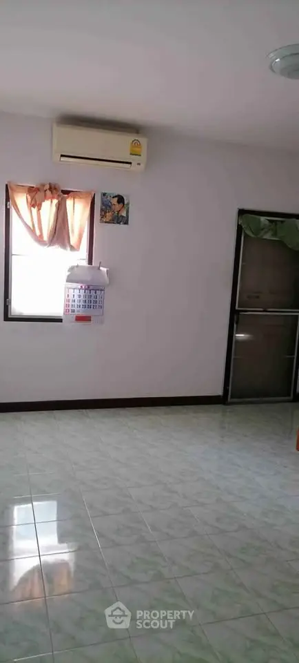 Spacious room with air conditioning and tiled flooring, perfect for versatile living arrangements.