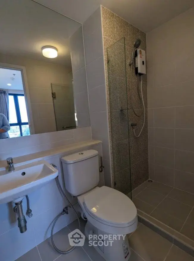 Modern bathroom with sleek fixtures and glass shower enclosure in a contemporary apartment.