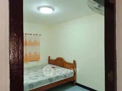 Cozy bedroom with wooden bed frame and soft lighting, perfect for restful nights.