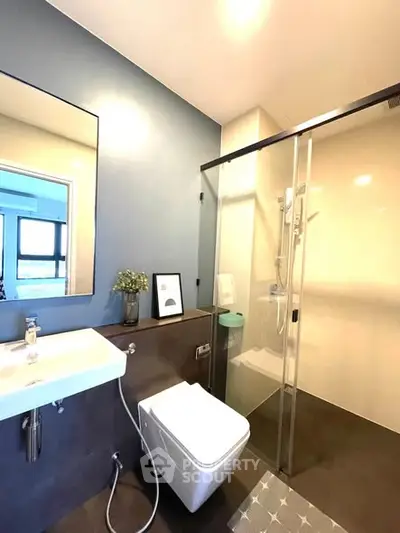Modern bathroom with sleek design, featuring a glass shower and stylish fixtures.