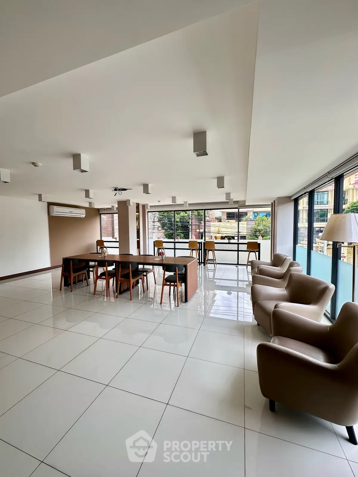 Spacious modern living area with large windows and stylish furniture, perfect for entertaining and relaxation.