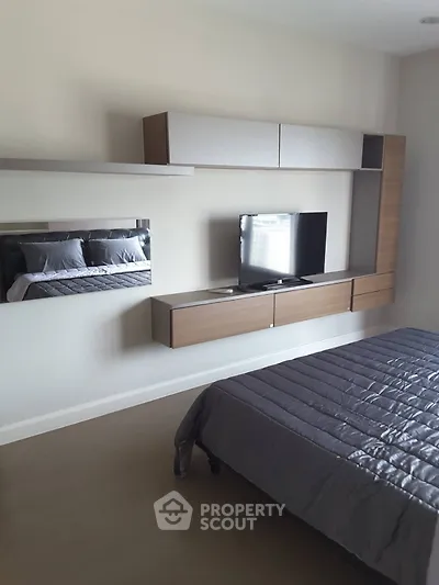 Modern bedroom with sleek wall-mounted TV and stylish storage units.