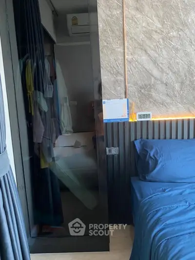 Modern bedroom with stylish decor and built-in closet, featuring elegant lighting and cozy bedding.