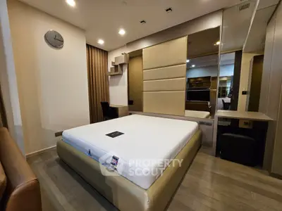 Luxurious modern bedroom with elegant decor and spacious layout, featuring a stylish bed and mirrored wardrobe.