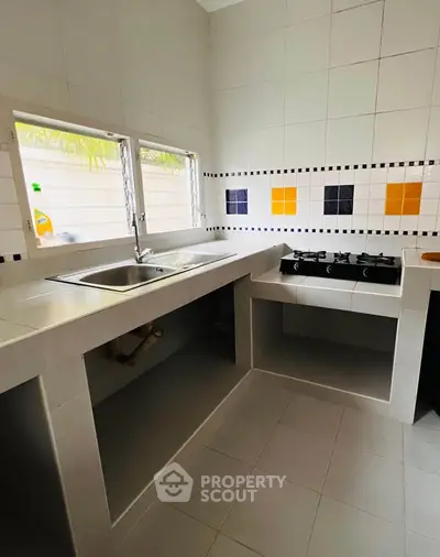 Modern kitchen with gas stove and tiled backsplash, featuring a sleek open layout.