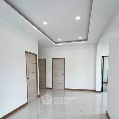 Spacious modern room with elegant tile flooring and recessed lighting, perfect for versatile living space.