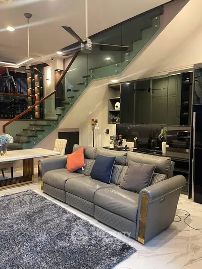 Luxurious modern living room with elegant staircase and plush seating