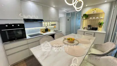 Modern kitchen with sleek white cabinets, marble countertops, and built-in appliances for luxury living.