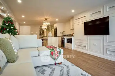 Spacious living room with modern decor and Christmas tree, featuring a large TV and elegant lighting.