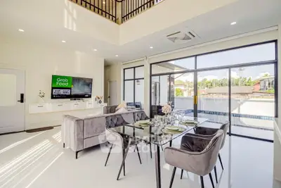 Luxurious open-plan living room with elegant dining area and abundant natural light.
