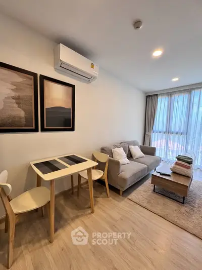 Modern living room with cozy sofa, dining table, and air conditioning in a bright apartment.