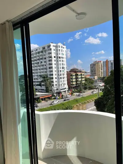 Modern apartment balcony with city view and clear blue sky