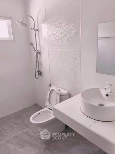 Modern minimalist bathroom with sleek fixtures and elegant white design.