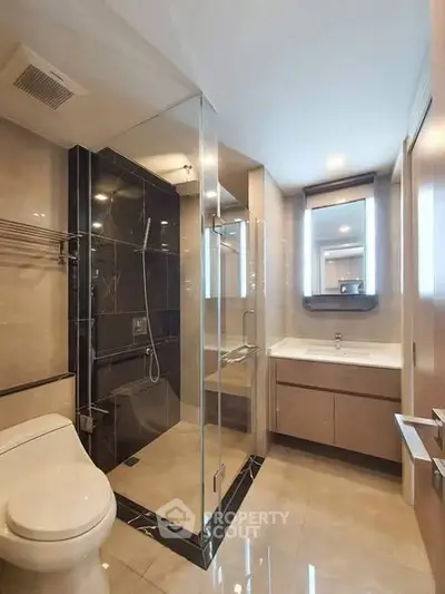 Modern bathroom with glass shower and sleek fixtures in a contemporary apartment.