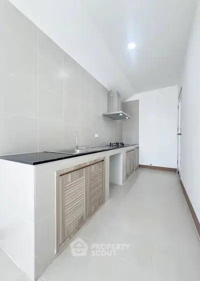 Modern kitchen with sleek design and gas stove in a spacious layout.