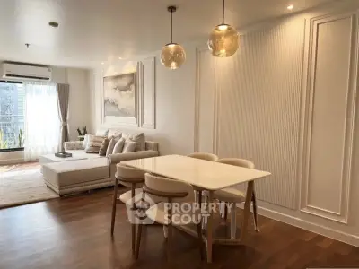 Elegant living room with modern dining area and stylish lighting in a cozy apartment.