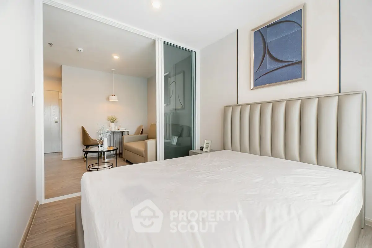 Modern bedroom with elegant decor and adjacent dining area in a stylish apartment.