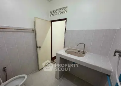 Simple bathroom with tiled walls and a basic sink setup.
