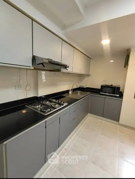 Modern kitchen with sleek cabinetry and gas stove in a contemporary apartment.