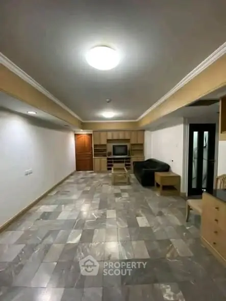 Spacious living room with modern tile flooring and built-in entertainment center.