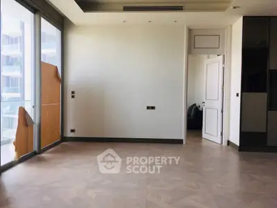Spacious modern living room with large windows and elegant flooring in a luxury apartment.