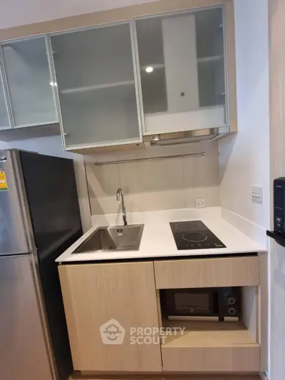 Modern compact kitchen with sleek cabinetry and built-in appliances