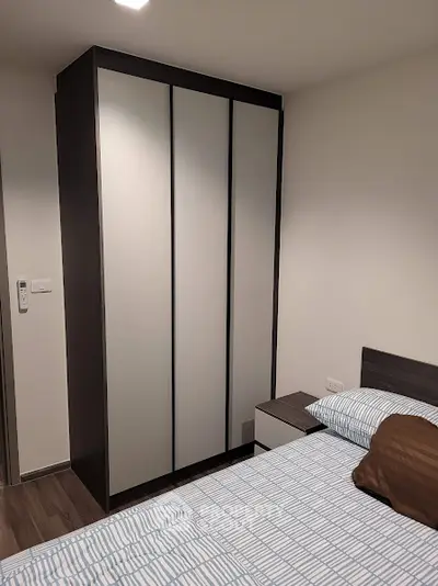 Modern bedroom with sleek wardrobe and cozy bedding in stylish apartment.