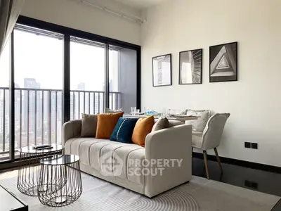 Chic modern living room with plush sofa, stylish armchair, and expansive windows offering an urban view, perfect for upscale city living.