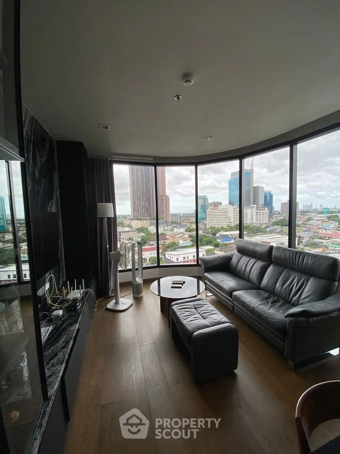 Luxurious living room with panoramic city view and modern furnishings.