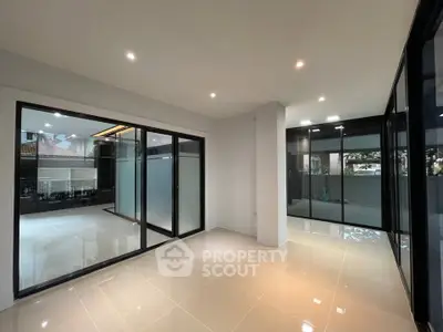 Spacious modern living room with large windows and sleek tile flooring