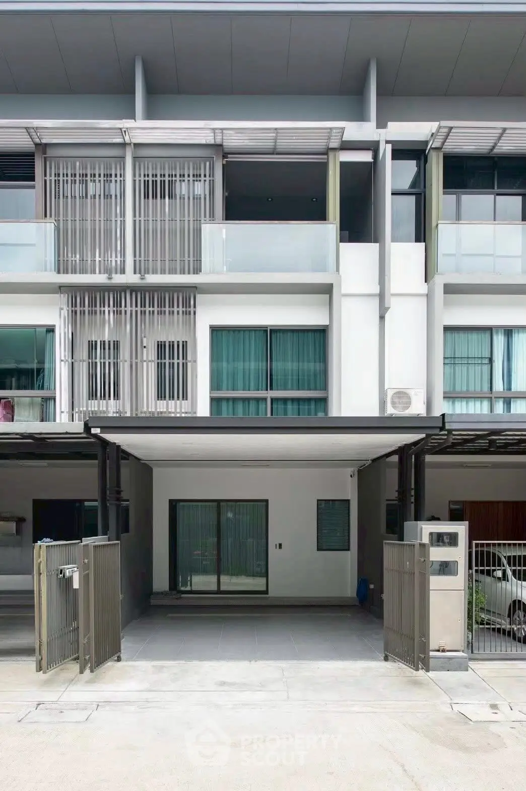 Modern townhouse exterior with sleek design and glass balconies
