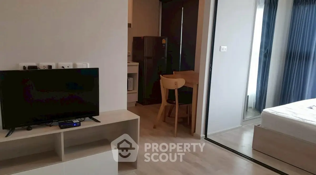 Modern studio apartment with open layout, featuring a cozy living area and compact kitchen.