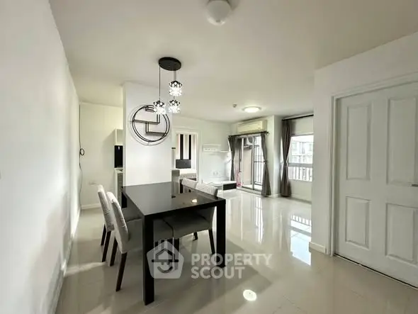 Modern dining area with sleek table and chairs, bright open space, and stylish lighting.