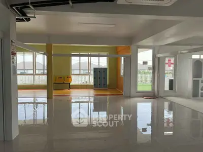 Spacious modern interior with glossy floors and large windows, ideal for versatile use.