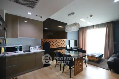 Modern open-plan kitchen and living room with elegant decor and natural light.