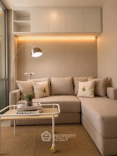 Cozy living room with beige sectional sofa, modern floor lamp, and stylish coffee table.