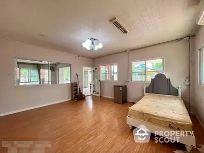 Spacious bedroom with hardwood floors, ample natural light, and a view of the secure fenced yard, ideal for a restful retreat.