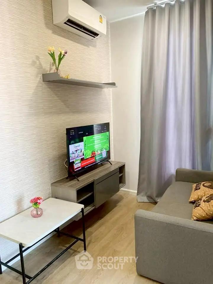 Cozy living room with modern decor and air conditioning, featuring a stylish TV setup.